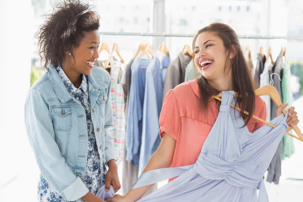 Two women looking at clothes in a clothing store.