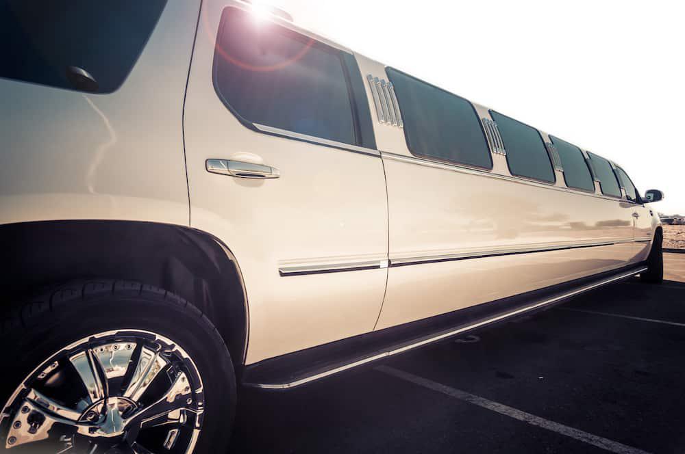 A white limo is parked in a parking lot, ready to serve bachelorette parties in Mansfield or Grand Prairie.