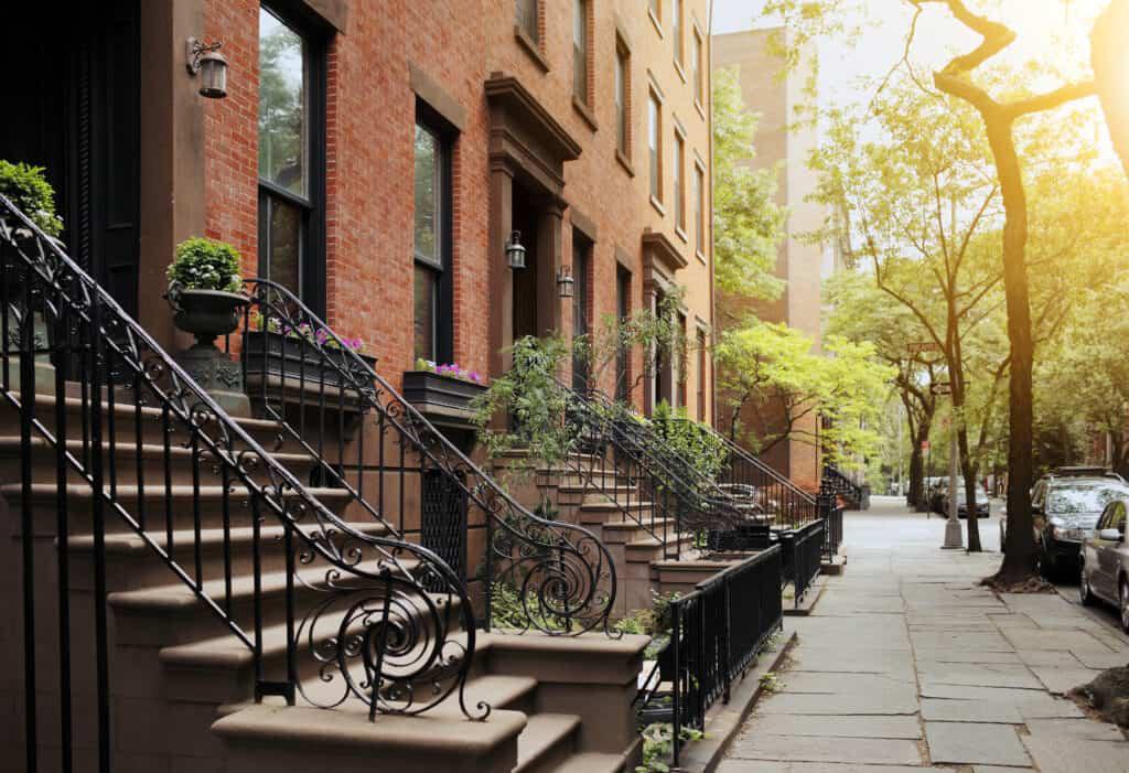 A row of brick buildings with wrought iron railings.