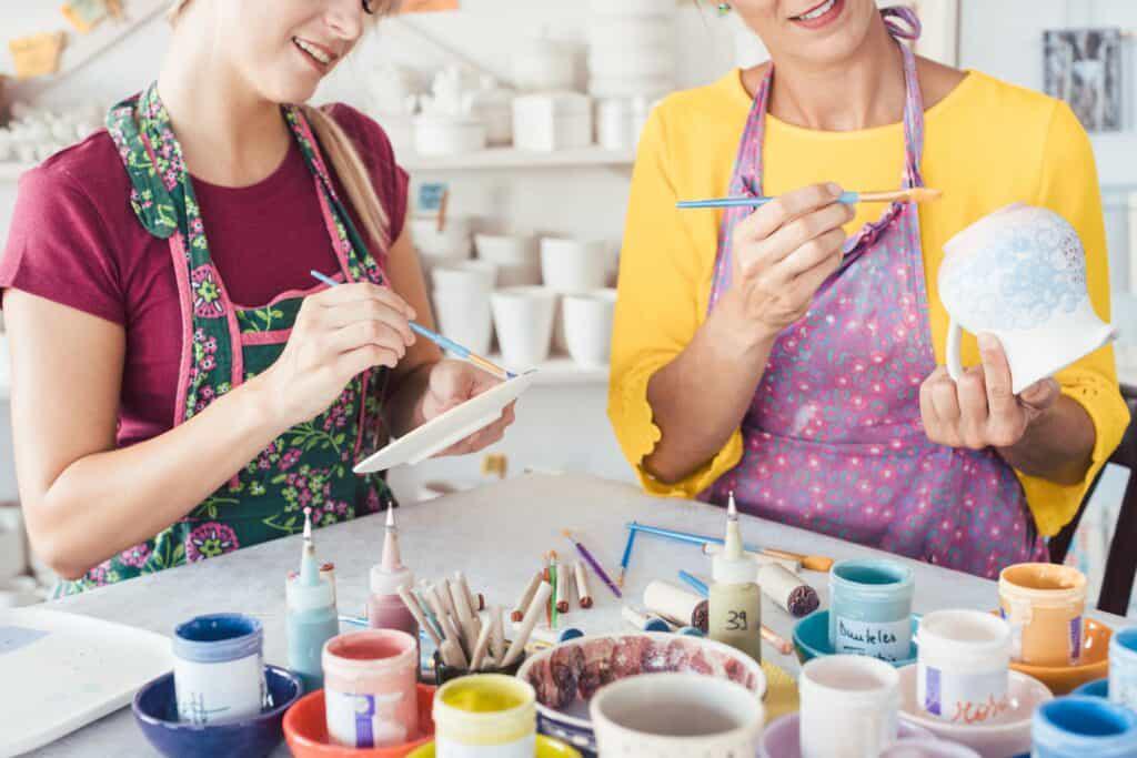 Two women working together in a pottery studio.