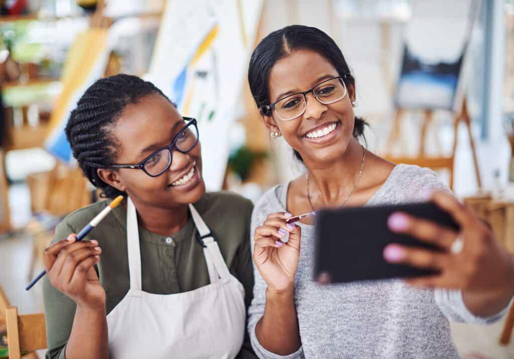 Two women taking a selfie in an art studio.