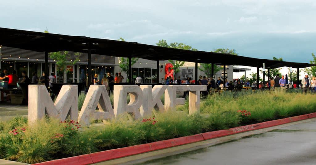Outdoor View of 8th Street Market at an Angle. Sign That Says MARKET out in front of building.