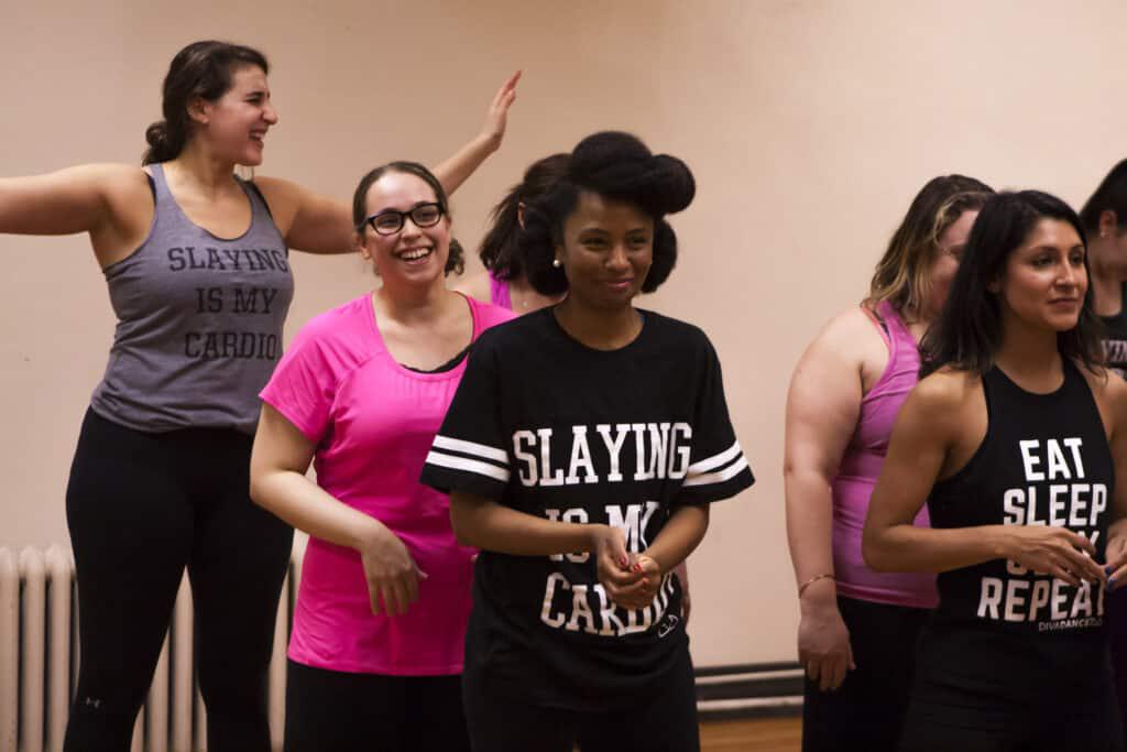 Adults learning choreography together in a DivaDance class, high energy and smiling
