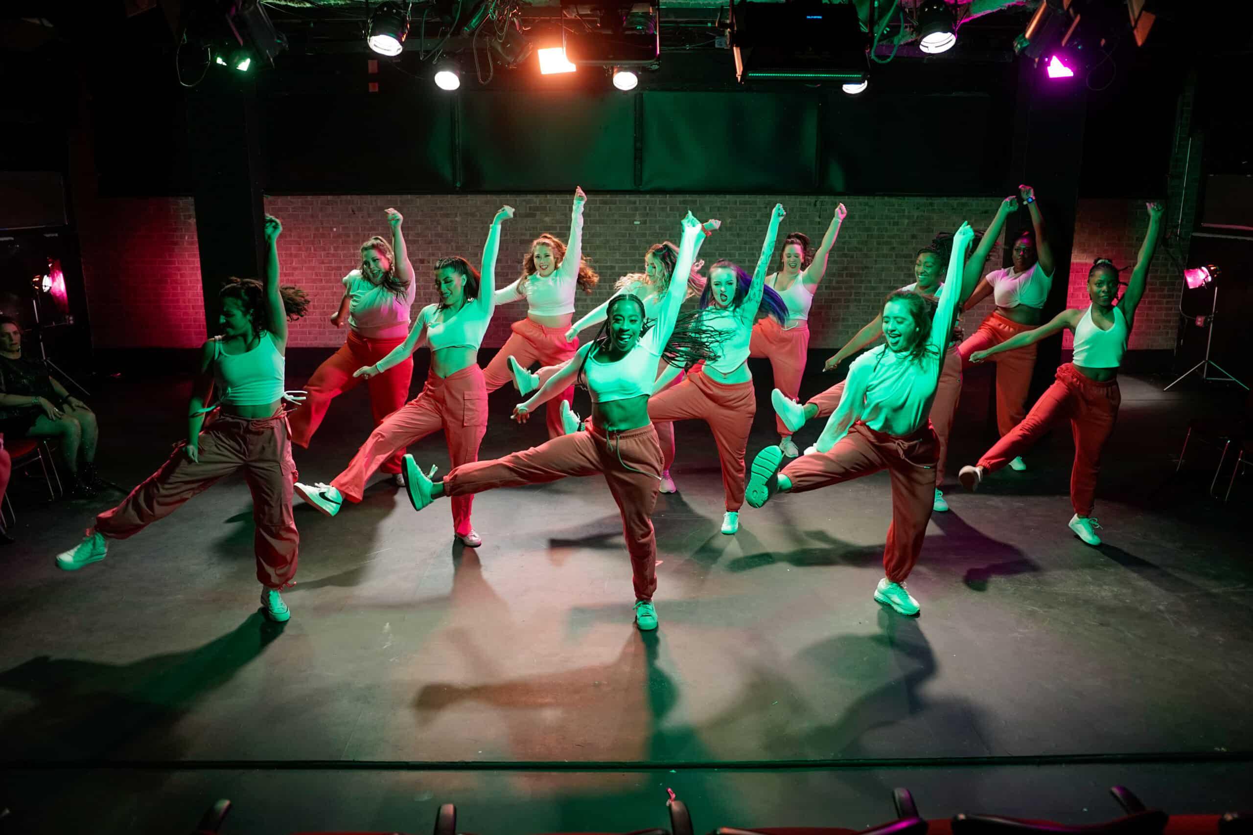 DivaDance performers on stage at a recital, celebrating progress and community.