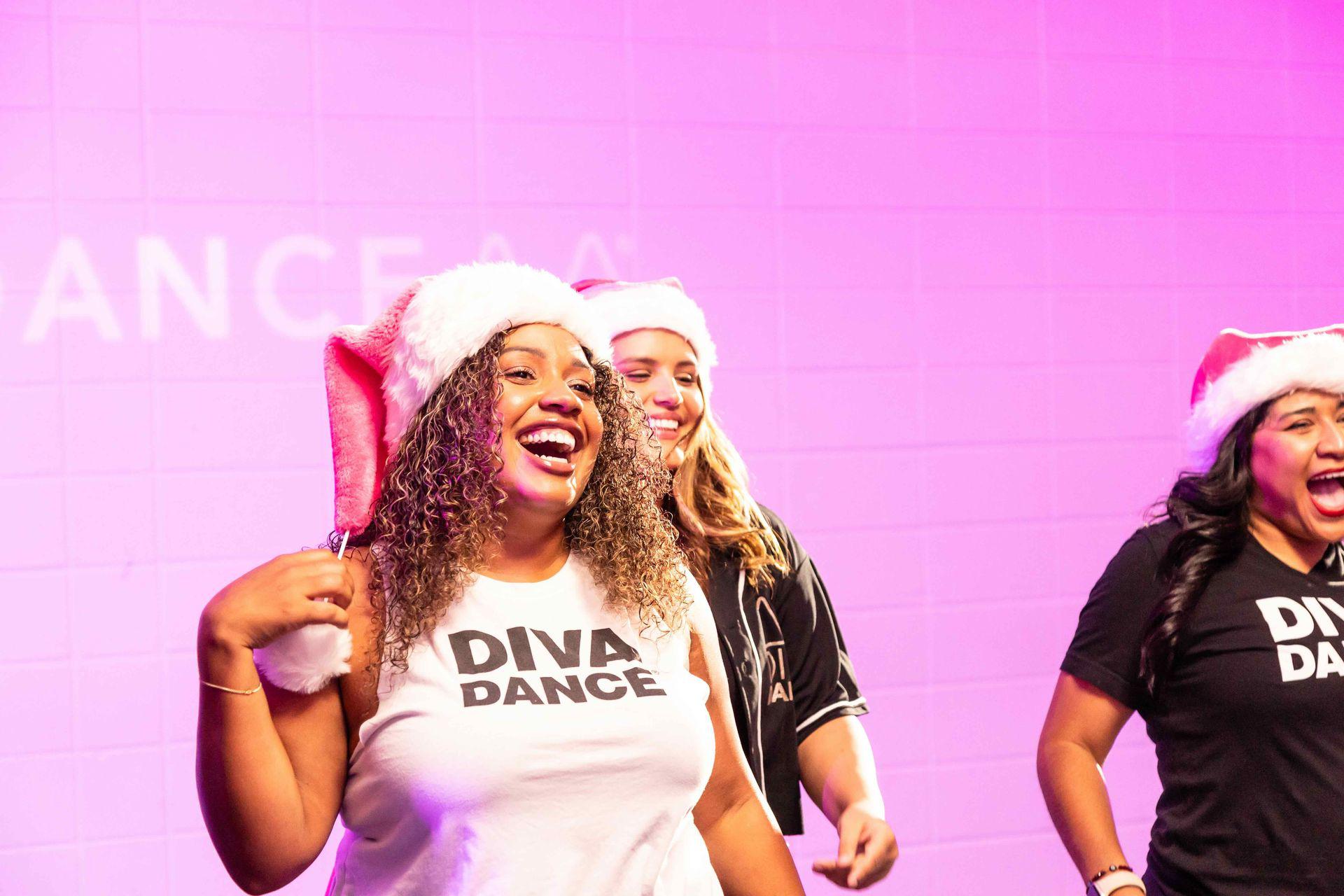 Two DivaDance members in Santa hats laughing during a Christmas in July class