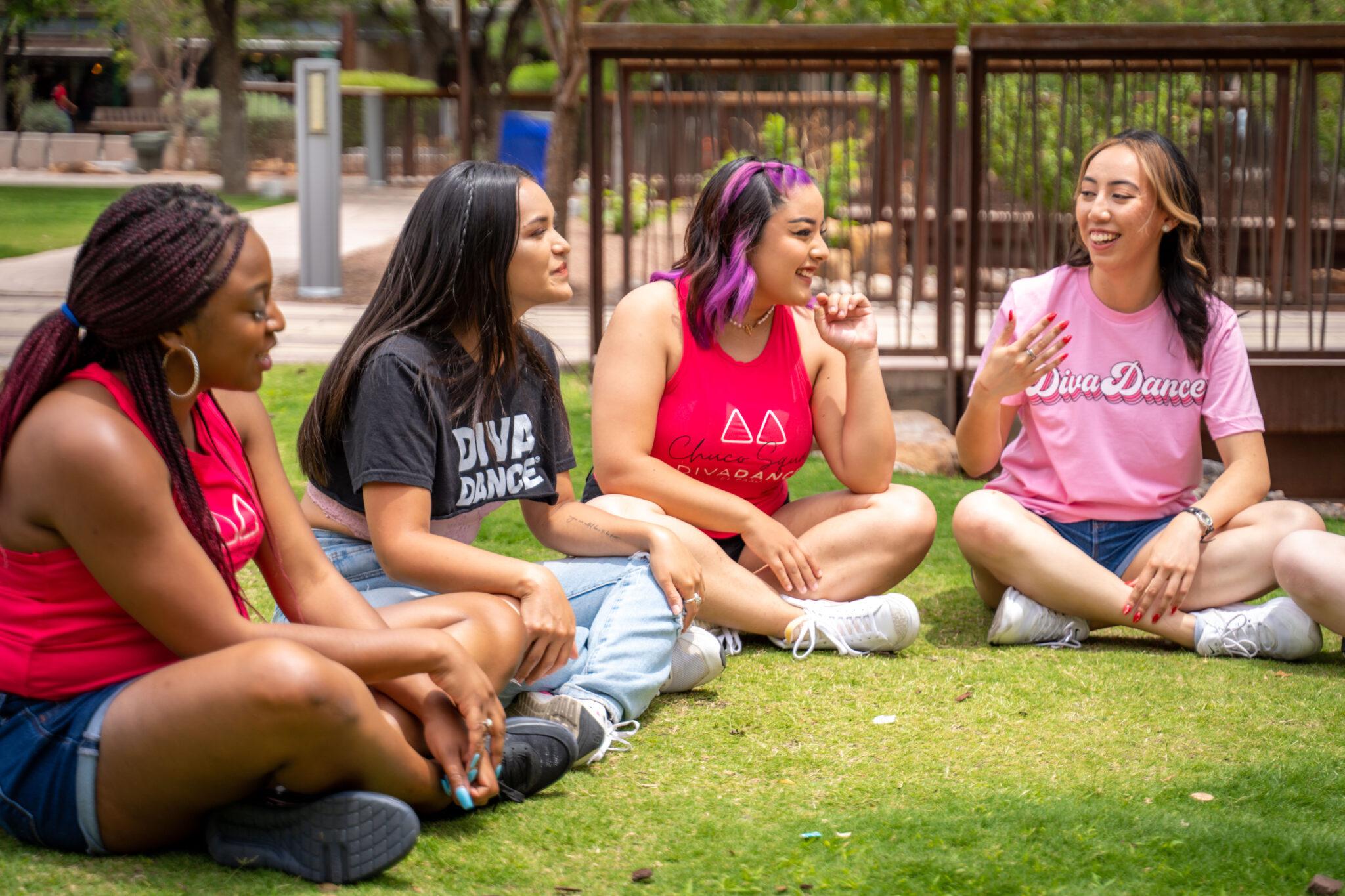 A group of women sitting in the grass talking about building healthy habits