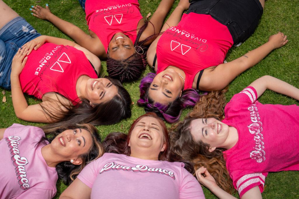 divadance logo and members of DivaDance lying in the grass