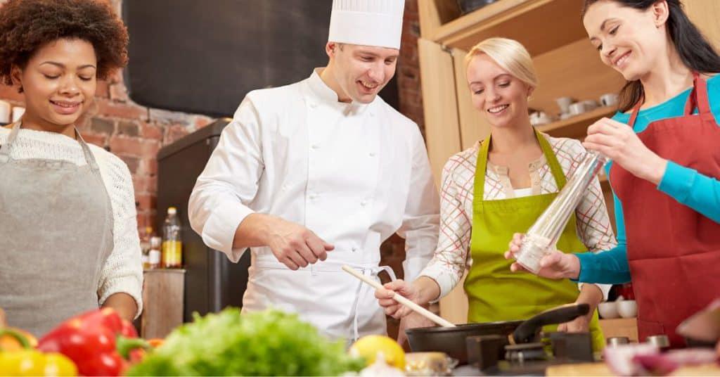 Three women learning how to cook on Galentine's Day with a male chef