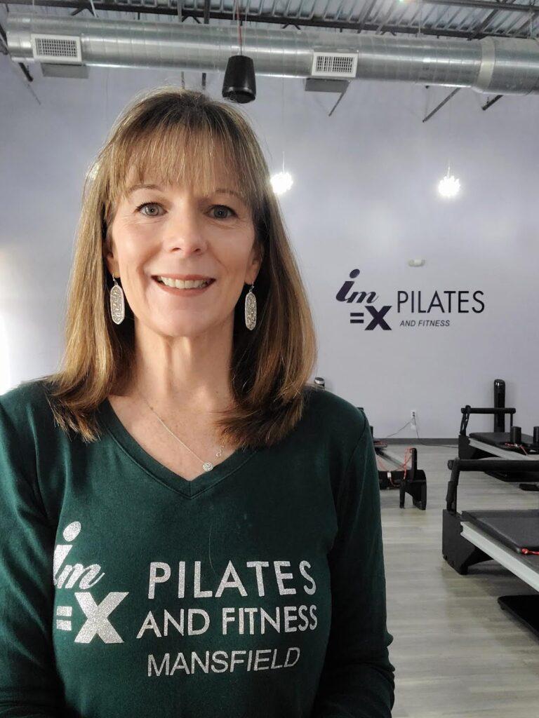 Woman standing in gym smiling