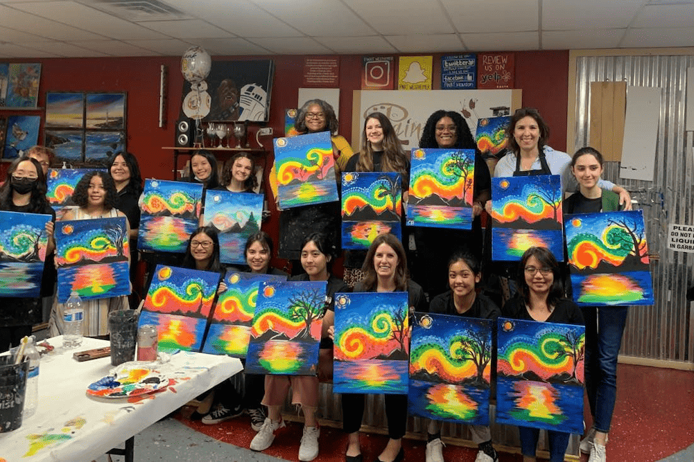 A group of women posing for a picture in an art class.