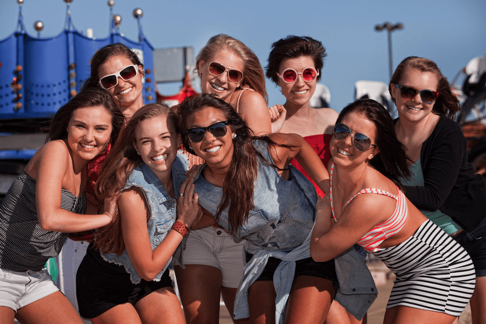 A group of young women posing for a photo at an amusement park during one of their bachelorette parties in Hoboken.