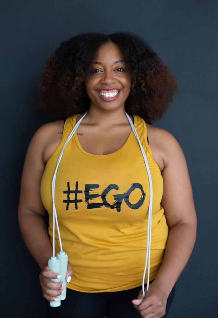 Woman standing, smiling and with jump rope around her neck