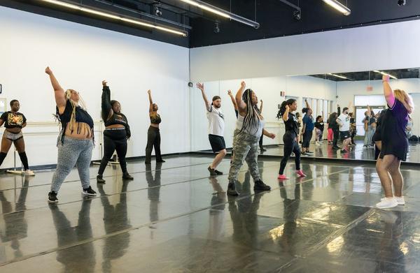 Beginner adults learning a dance routine in a DivaDance class