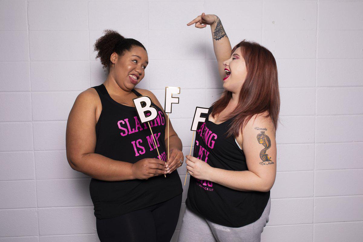 Two best friends laughing with BFF photo props at a DivaDance event