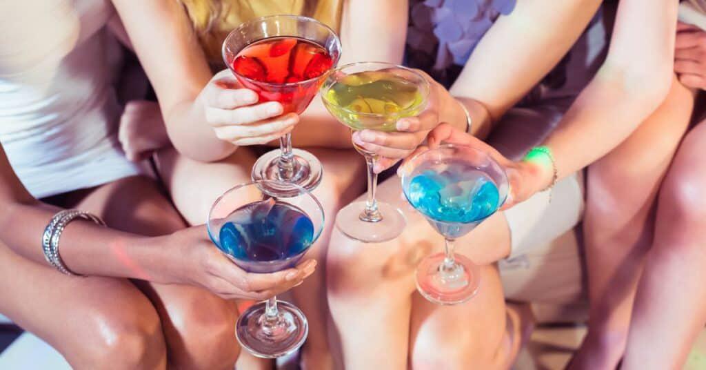 Closeup of four women clinking glasses