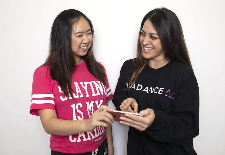 Two Women Talking and Looking at a Phone