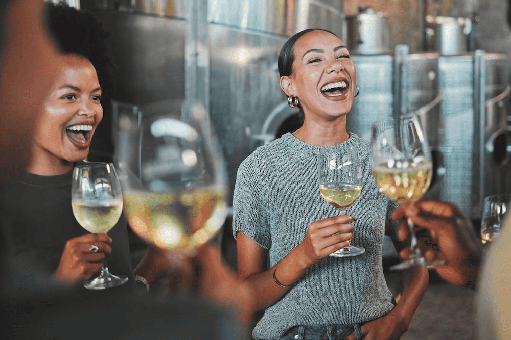 A group of people enjoying wine at a winery for a bachelorette party in Fredericksburg.